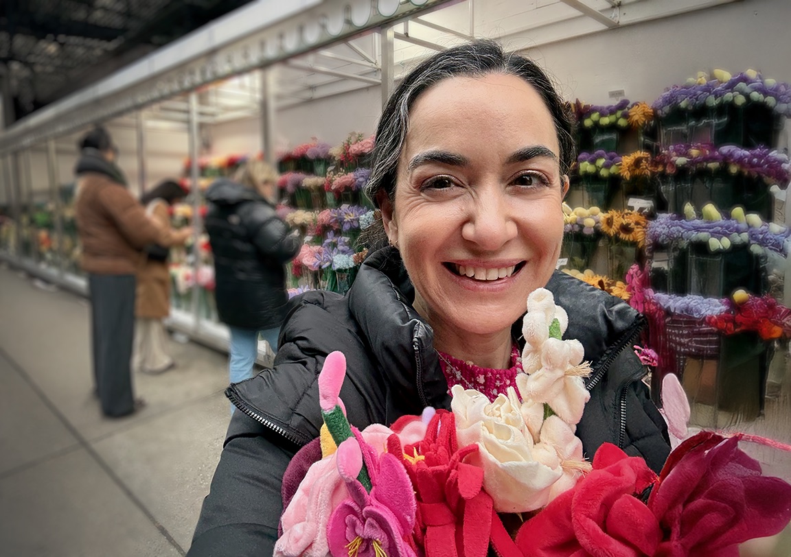 Jennifer Fragale smiling, holding a bouquet at a flower market